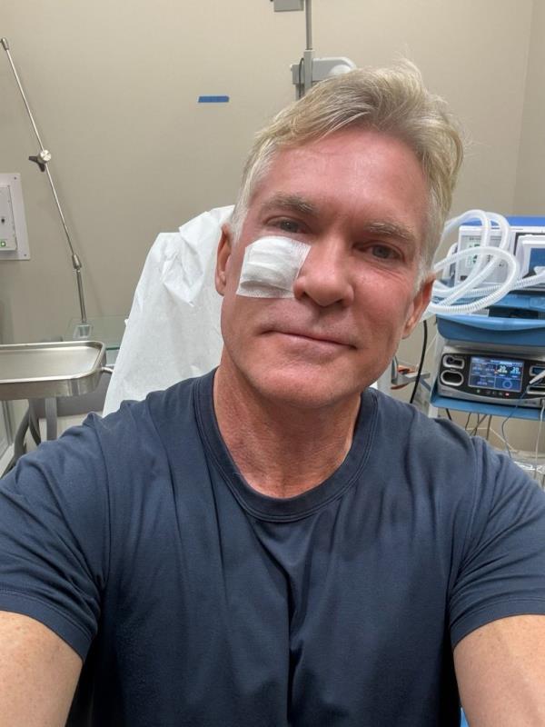 Sam Champion smiling with a band aid near his eye. 