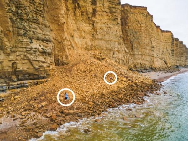 BNPS.co.uk (01202 558833) Pic: JamesLoveridgePhotography/BNPS Reckless tourists clamber over the huge rockfall despite the danger of other landslips happening at the cliffs. WITH VIDEO https://www.youtube.com/watch?v=KHQ_VWN3p0g This is the terrifying moment three people run for their lives to avoid being crushed under a huge rockfall. Dramatic video footage has emerged showing the very moment 400 to<em></em>nnes of rock and boulders the size of cars broke away from unstable cliffs. The trio of tourists were stood on the beach immediately below the 150ft sandstone cliffs on Britain's Jurassic Coast at West Bay, Dorset, at the time.