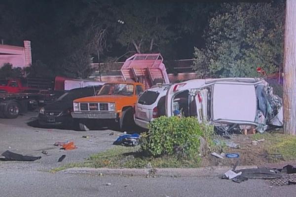 The wrecked car lies on top of other parked cars.