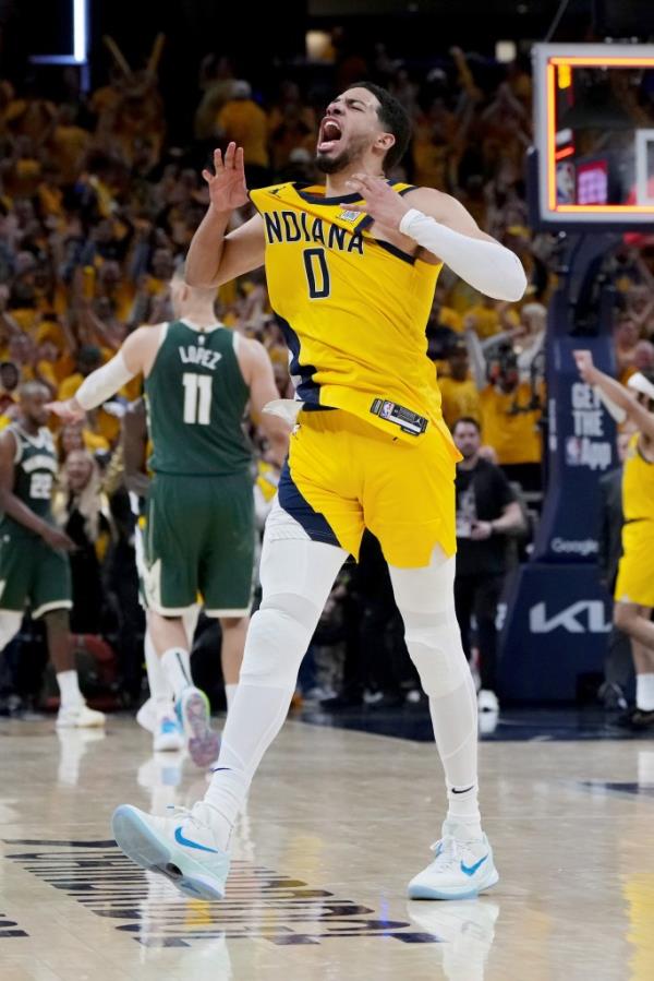 Indiana Fever players Aliyah Boston, left, and Caitlin Clark throw tee-shirts to fans during a time out during the first half between the Indiana Pacers and the Milwaukee Bucks in Game 2 in an NBA basketball first-round playoff series