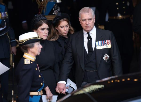 Queen Elizabeth II's coffin on Gun Carriage, surrounded by Princess Anne, Princess Eugenie, Princess Beatrice, and Prince Andrew in military attire, during its procession from Buckingham Palace to Westminster Hall