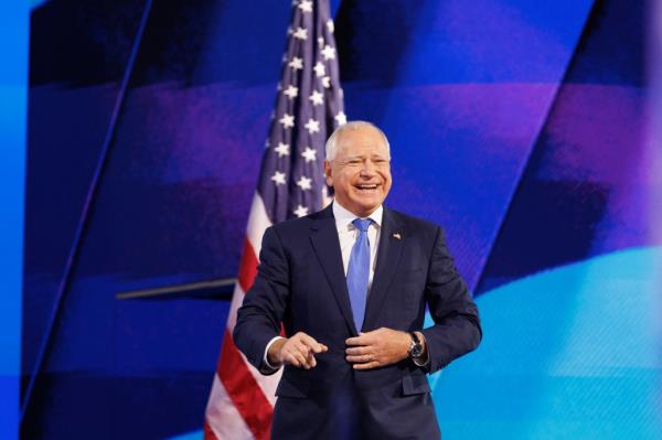 Governor Tim Walz accepting the VP nomination at the DNC Co<em></em>nvention in Chicago, standing in front of a flag