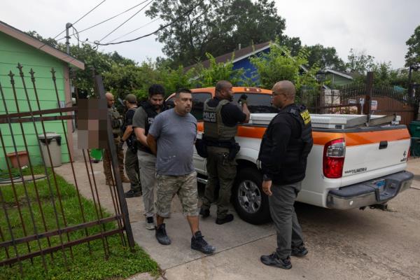 ICE officers take Rosvelt Arturo Sanchez Sanchez, 39, into their vehicle after arresting him at his home in Houston, Texas.