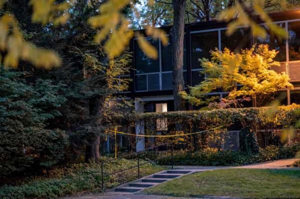 The Isaac Agree Downtown Synagogue building, blocked in part by trees with yellow and green autumn leaves. Near the steps leading to the building is a strip of yellow police tape blocking a walkway.