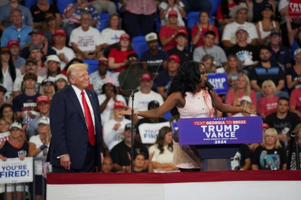Michaelah Mo<em></em>ntgomery speaking at a podium during a Do<em></em>nald Trump campaign rally, with Trump and Senator JD Vance in the background, Atlanta, Georgia, 2024