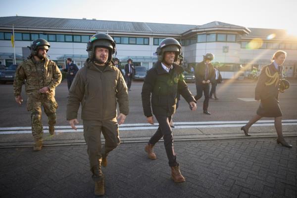 British Prime Minister Rishi Sunak, right, and Ukrainian President Volodymyr Zelenskyy, left, board a Royal Air Force Chinook helicopter