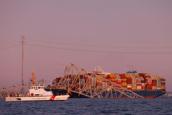 A US Coast Guard vessel secures the perimeter, after the Dali cargo vessel crashed into the Francis Scott Key Bridge causing it to collapse in Baltimore, Maryland.