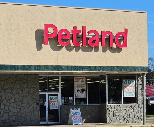 The outside of a Petland store and its red sign is pictured under blue sky