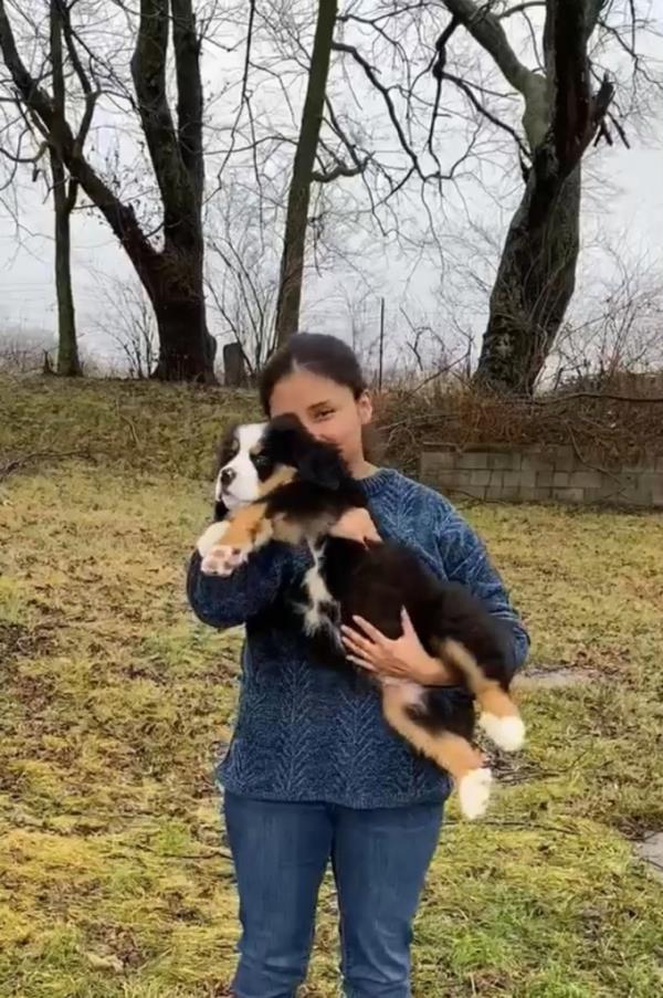 Miriam Arena holds a puppy while standing outside