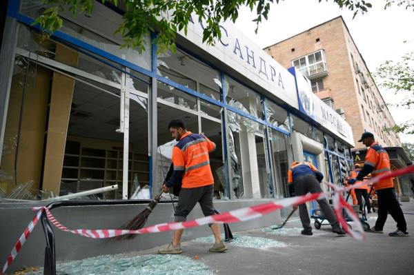 Workers sweep up broken glass at a damaged building after a reported drone attack in Moscow, Russia, on July 24, 2023. 