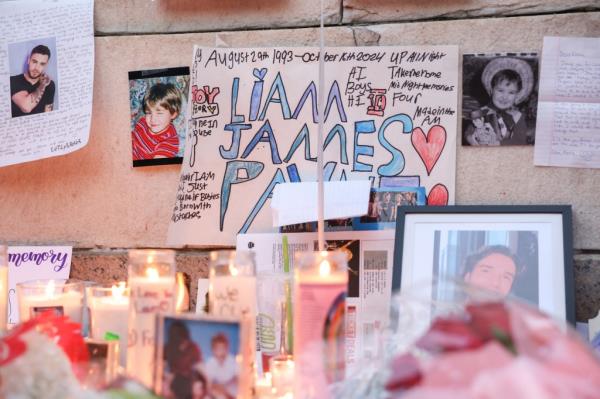 Fans built a makeshift memorial and embraced it as they sang along to Payne's music. 