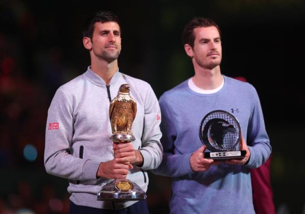 Serbia's Novak Djokovic (L) poses with the winner's trophy after beating Britain's Andy Murray during their final tennis match at the ATP Qatar Open in Doha on January 7, 2017. 