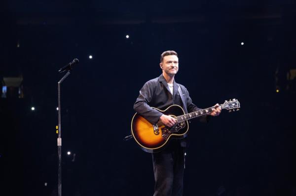 Justin Timberlake on stage with a guitar.
