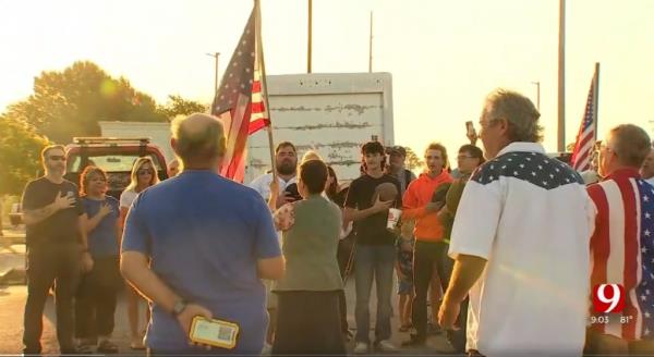 The group gathered in the school's parking lot around 7 a.m. on Monday, peacefully protesting the school's policy and even reciting the pledge of allegiance during the demonstration.