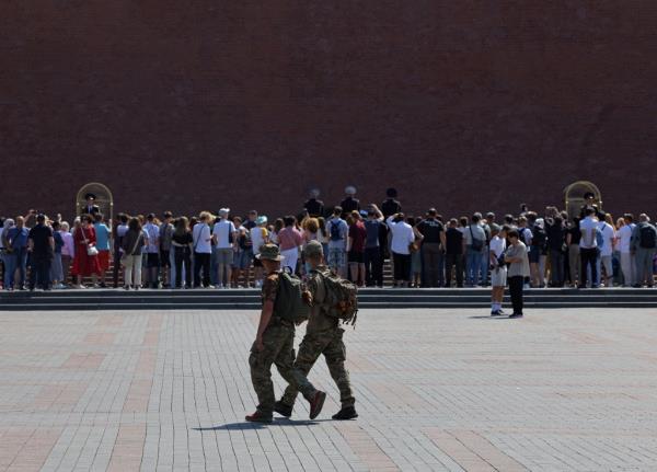 People wearing a camouflage uniform walk past the Tomb of the Unknown Soldier by the Kremlin wall in Moscow, Russia June 25, 2023. 