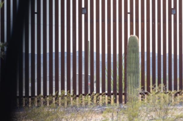 Two vehicles driven by cartel smugglers drive away from the open border wall after dropping off migrants.