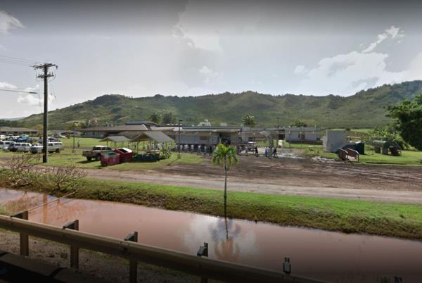 Kauai Community Correctio<em></em>nal Center building surrounded by flooded area with a hill in the background