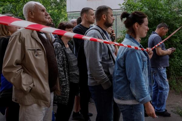 People react at a site of the residential building heavily damaged by a Russian missile strike in Kryvyi Rih, Ukraine, on June 13, 2023. 