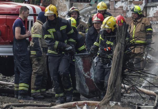Rescuers carry the body of a person killed by a Russian missile strike in Kryvyi Rih on June 13, 2023.