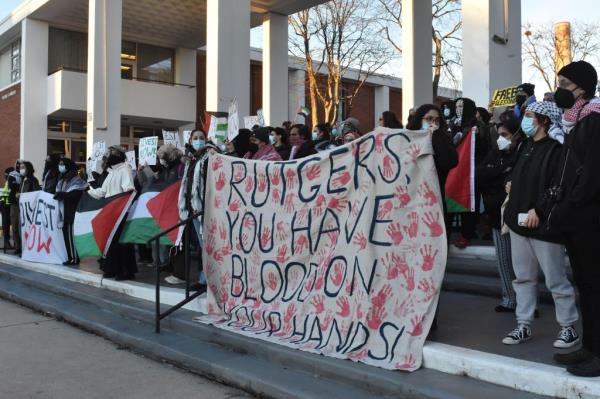 Protesters at Rutgers University holding a banner says, 