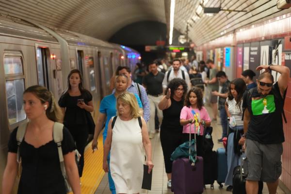 Commuters wait for a train in NYC.