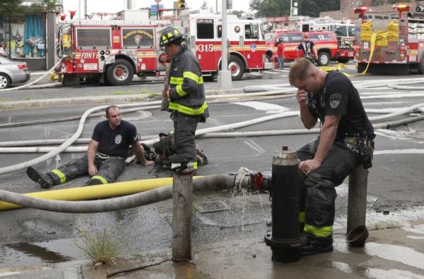 Exhausted firefighters resting while battling the blaze.