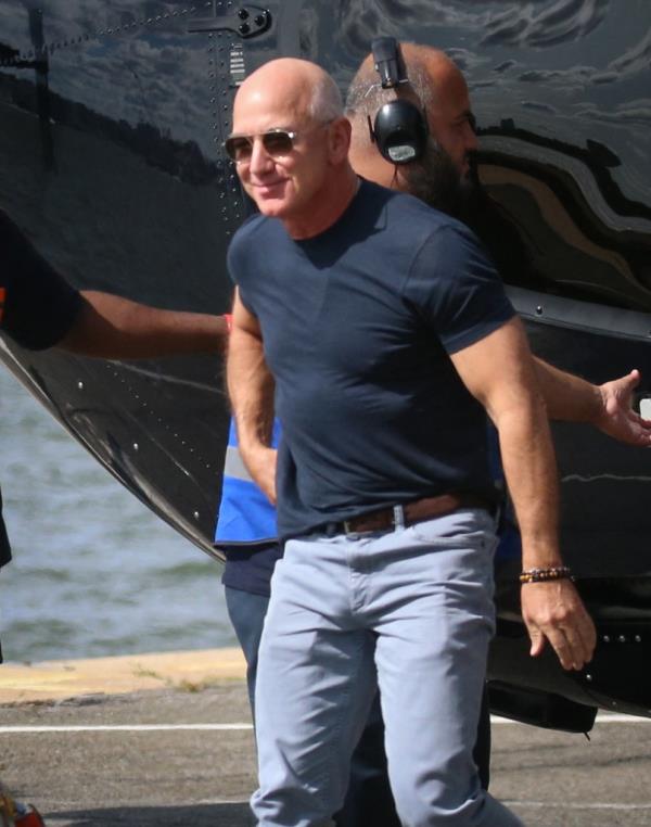 Jeff Bezos and Lauren Sanchez arriving at a Heliport in New York City, with Lauren Sanchez havin<em></em>g flown the helicopter herself, and now walking alo<em></em>ngside a bullet-proof vehicle with Bezos' security detail around them.