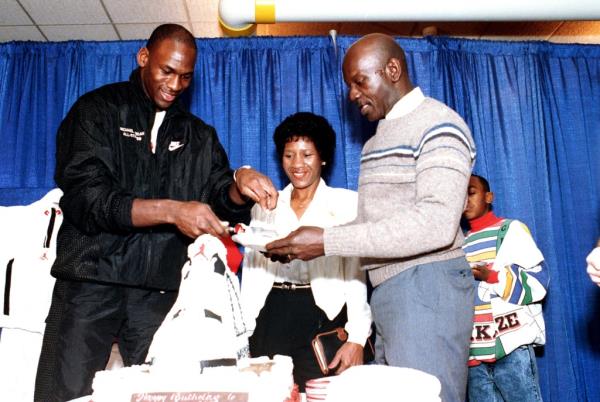Michael Jordan (l.) gives his father James (r.) a slice of birthday cake as mother Deloris (c.) looks on in 1989.
