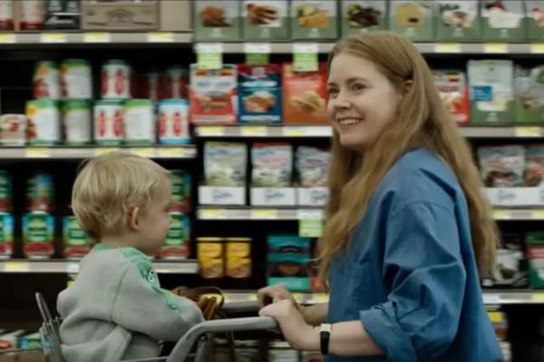 Amy Adams pushing a baby in a grocery cart