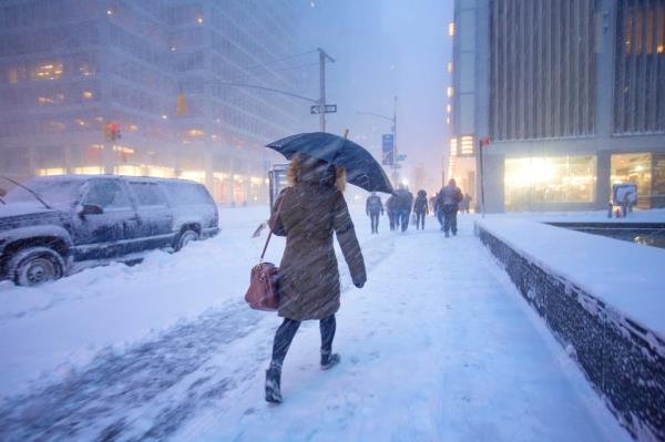 Man walking in the snow covered street during a blizzard in Manhattan.