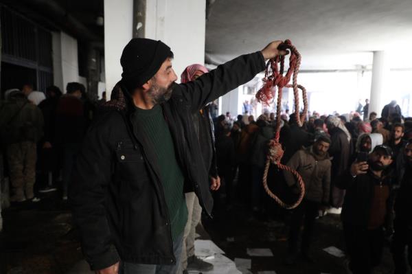 A man hold a bloody rope used on priso<em></em>ners at the infamous Saydnaya Prison.