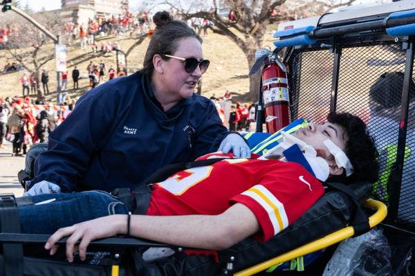 An injured person is aided near the Kansas City Chiefs' Super Bowl LVIII victory parade.