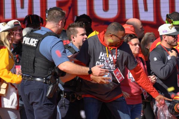 Police clear the Kansas City Chiefs from the stage after a shooting at their Super Bowl victory rally in Kansas City, Mo., Wednesday, Feb. 14, 2024.