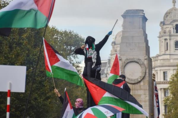 Mandatory Credit: Photo by Vuk Valcic/ZUMA Press Wire/Shutterstock (14160377bh) A protester climbs on a traffic light and sets off fireworks near The Cenotaph in Whitehall. Tens of thousands of people marched in central Lo<em></em>ndon in solidarity with Palestine as the Israel-Hamas war intensifies. Palestine Solidarity March in Central London, England, UK - 21 Oct 2023