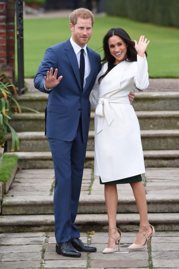 Prince Harry and Meghan Markle standing on stairs, announcing their engagement.