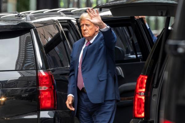 Former U.S. President Do<em></em>nald Trump waving to people as he arrives at Trump Tower during his trial in New York City