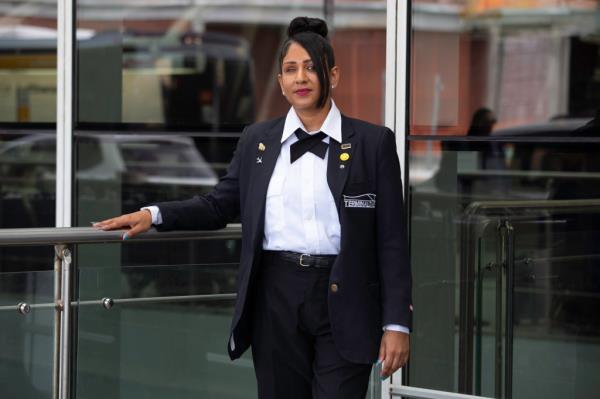 Elizabeth Gomes posing sadly in a suit outside of her workplace after hearing a court sentencing