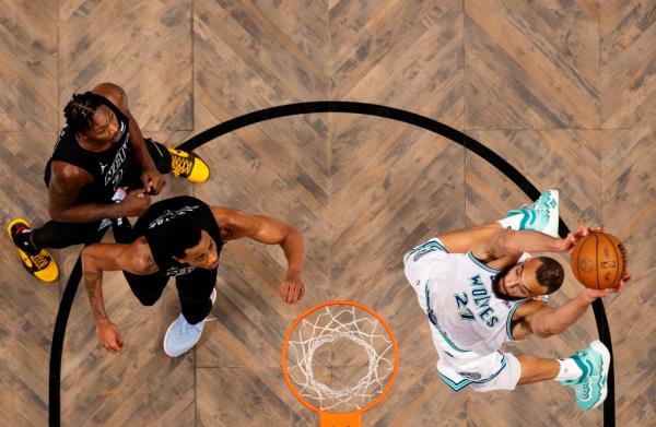 Rudy Gobert dunks against Nic Claxton and Cameron Johnson during a basketball game between Minnesota Timberwolves and Brooklyn Nets.