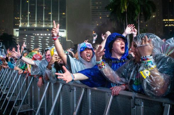 Festival attendees reacting in the rain during a Ti?sto set at the Ultra Music Festival in Bayfront Park, Miami, including Yu Fengtong and Akira Sasaki.