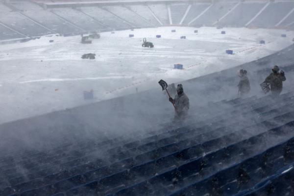 Workers remove snow from Highmark Stadium in Orchard Park, N.Y.