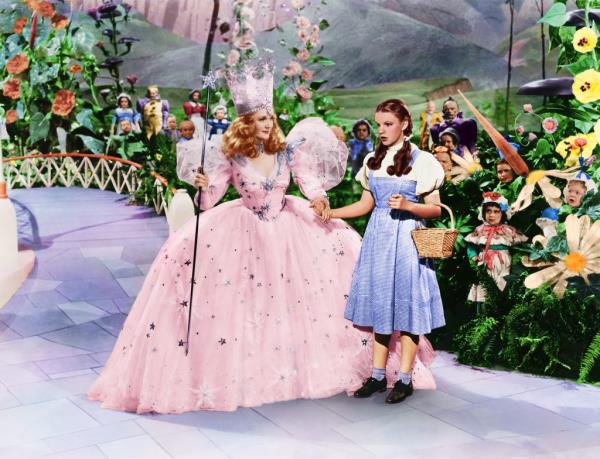 A nervous Dorothy holding hands with The Good Witch in the original movie.