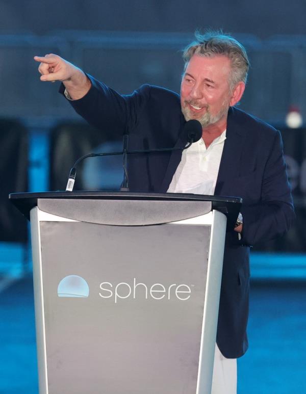 Dolan standing behind a podium and pointing.