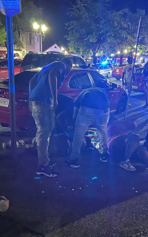 Bystanders helping a victim wounded outside Hush Cigar and Hookah Lounge.