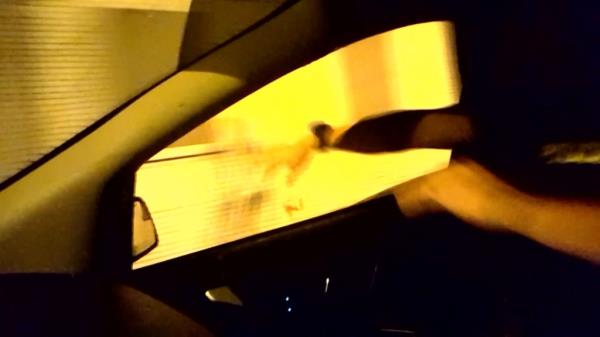 A screengrab of the footage shows a slushie being spilled out on a pedestrian as a cop car speeds by.