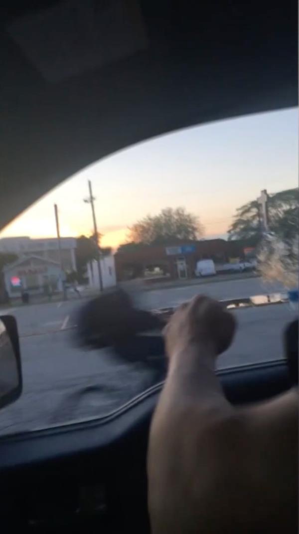 An officer is seen spilling out a slushie from a vehicle.
