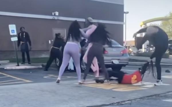 A still from a cell phone video showing a brawl in a McDonald's parking lot.