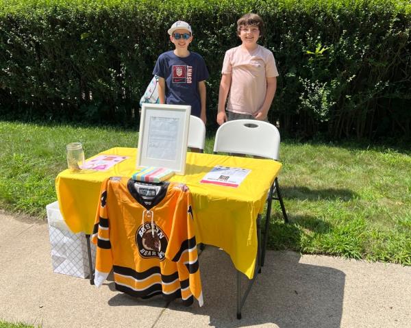 Ben and Danny Doherty stand near a table for donations