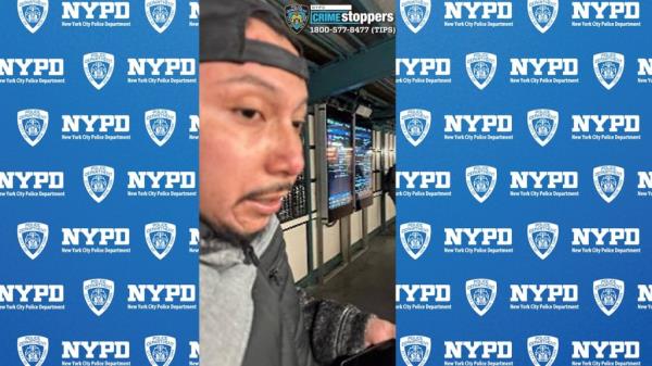 A photo of the unidentified suspect, a man with a thin mustache and beard, wearing a backwards ba<em></em>seball cap and black and gray jacket.