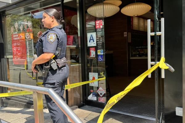 A phot of an NYPD officer standing guard at the crime scene Saturday.