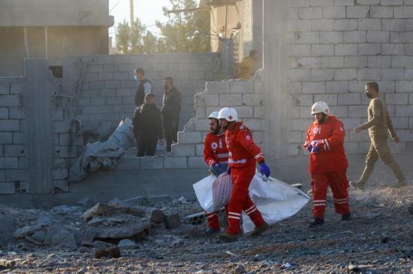 Rescuers in red uniforms evacuating bodies from the site of an Israeli airstrike in the eastern Lebanese city of Baalbek on November 14, 2024.